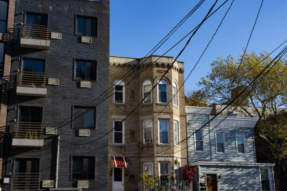 A variety of old brick homes and apartment buildings with overhead wires in Astoria Queens of New York City