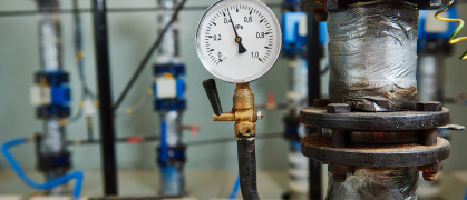 Closeup of manometer, pipes and faucet valves of heating system in a boiler room
