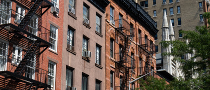Row of Colorful Old Brick Residential Buildings with Fire Escapes in Greenwich Village of New York City