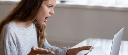 Shocked young woman read bad news in letter at home stock photo