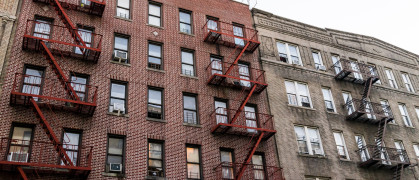 Brick apartment condo building exterior architecture in Fordham Heights center, Bronx, NYC, Manhattan, New York City with fire escapes, windows, ac units in evening stock photo