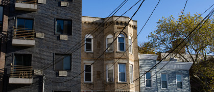 A variety of old brick homes and apartment buildings with overhead wires in Astoria Queens of New York City