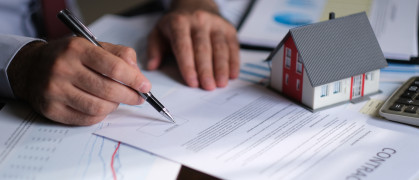 Businessman signing a mortgage contract of a sale for a new house