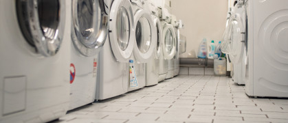 Laundry room of an apartment house in the basement with some washers in a row stock photo