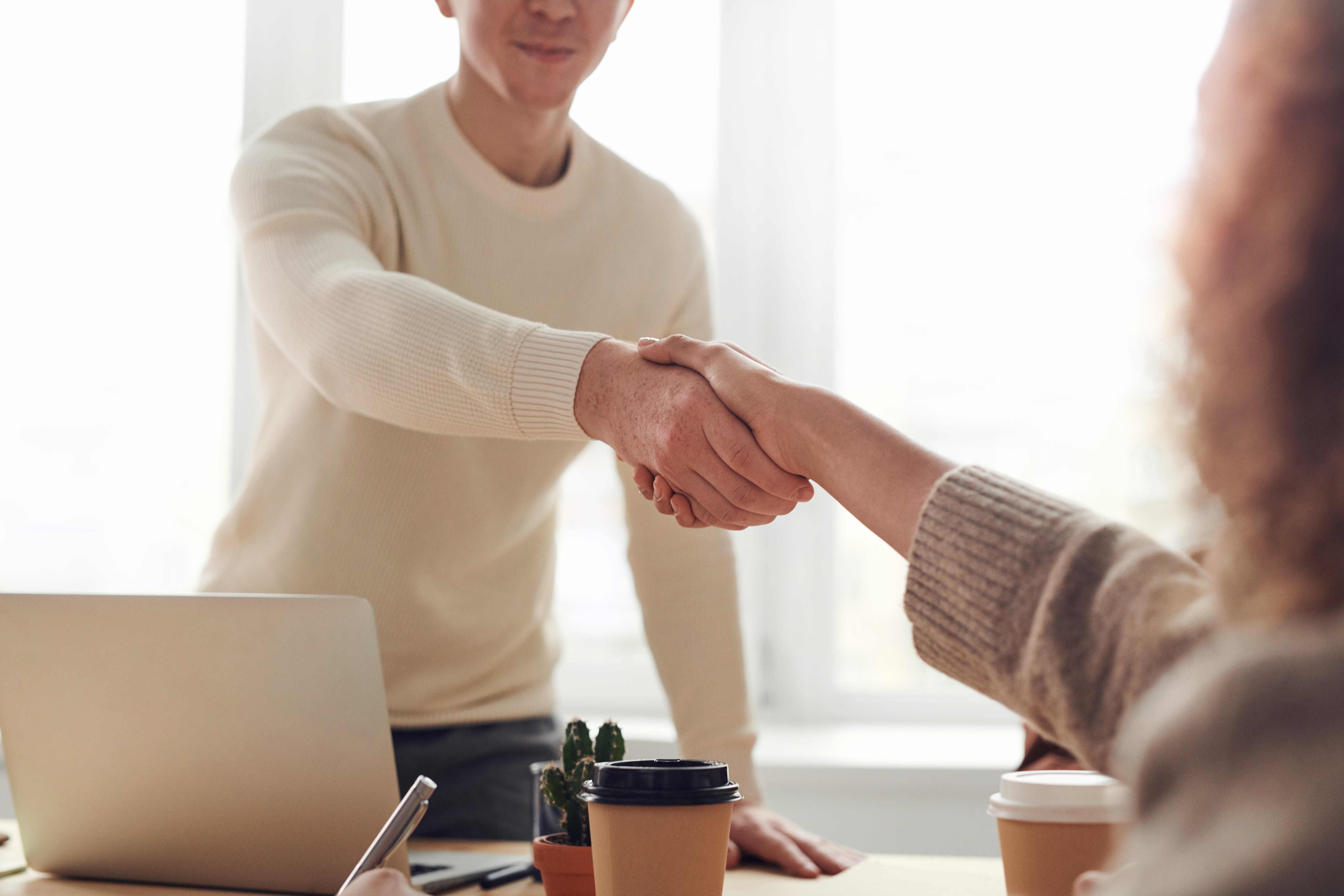 Picture of two people shaking hands at a desk