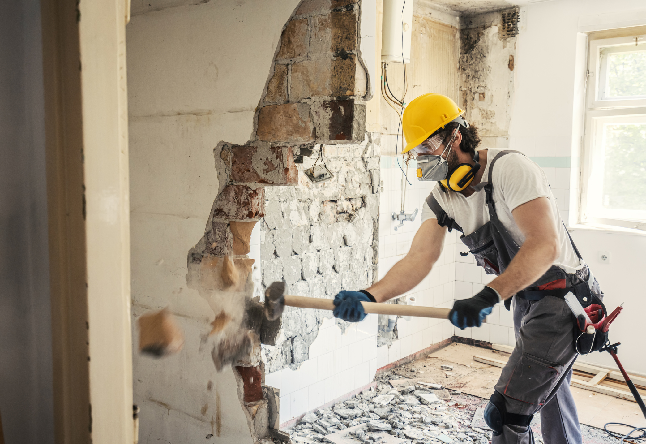 Worker using hammer to demo a wall