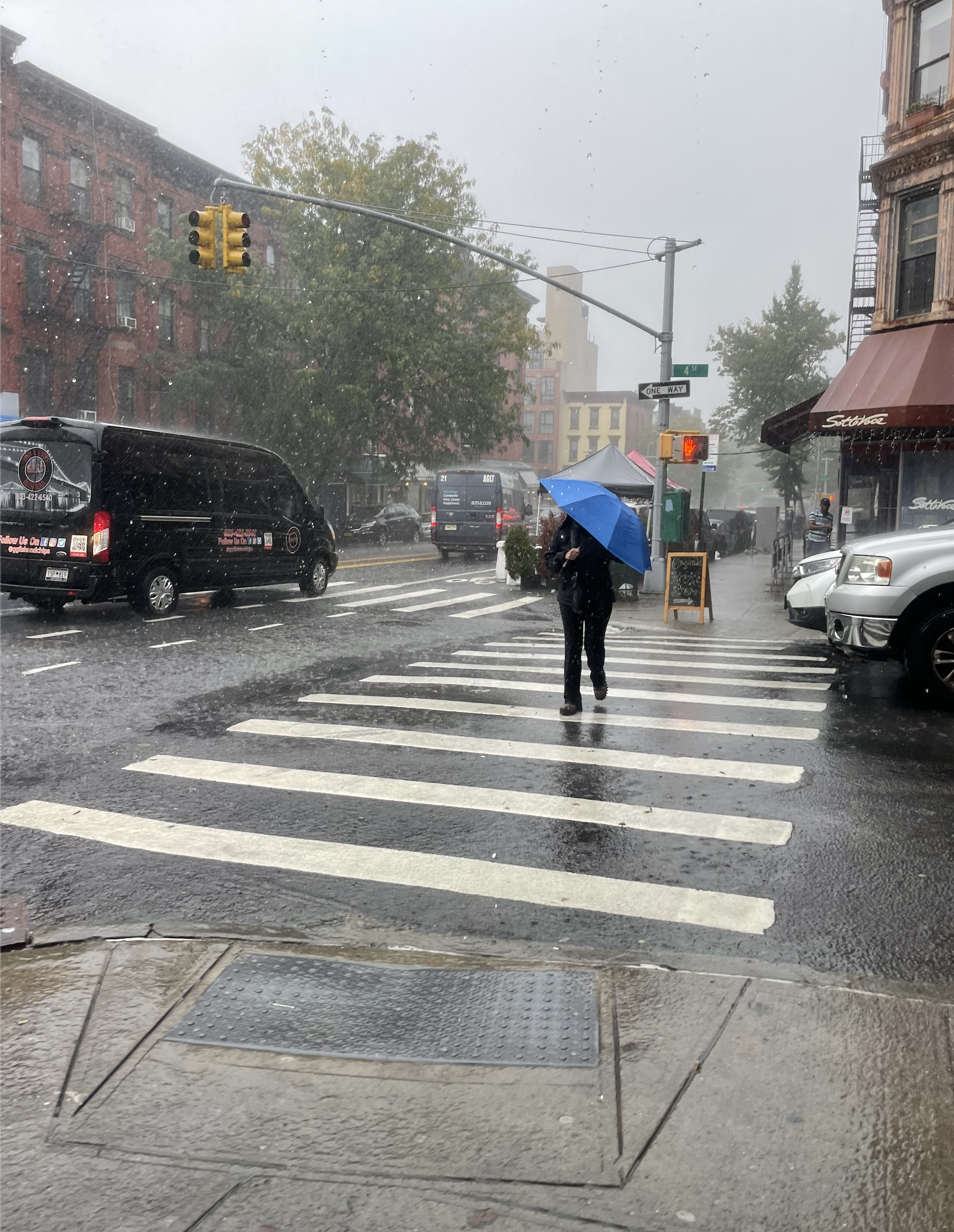 A person holds up an umbrella to the torrential downpour at 4th Street and Seventh Avenue in Park Slope, Brooklyn. A person holds up an umbrella to the torrential downpour at 4th Street and Seventh Avenue in Park Slope, Brooklyn.