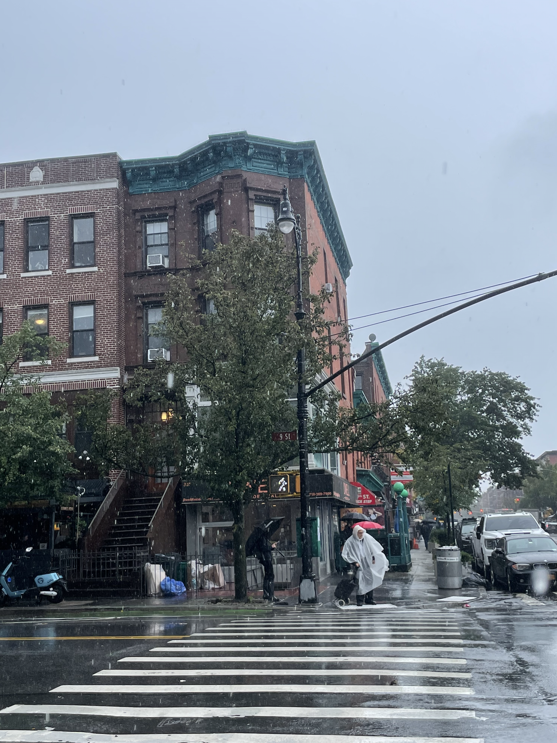 A man stands in a rain poncho as the rain pours on the corner of 9th Street and Seventh Avenue in Park Slope, Brooklyn. A man stands in a rain poncho as the rain pours on the corner of 9th Street and Seventh Avenue in Park Slope, Brooklyn.
