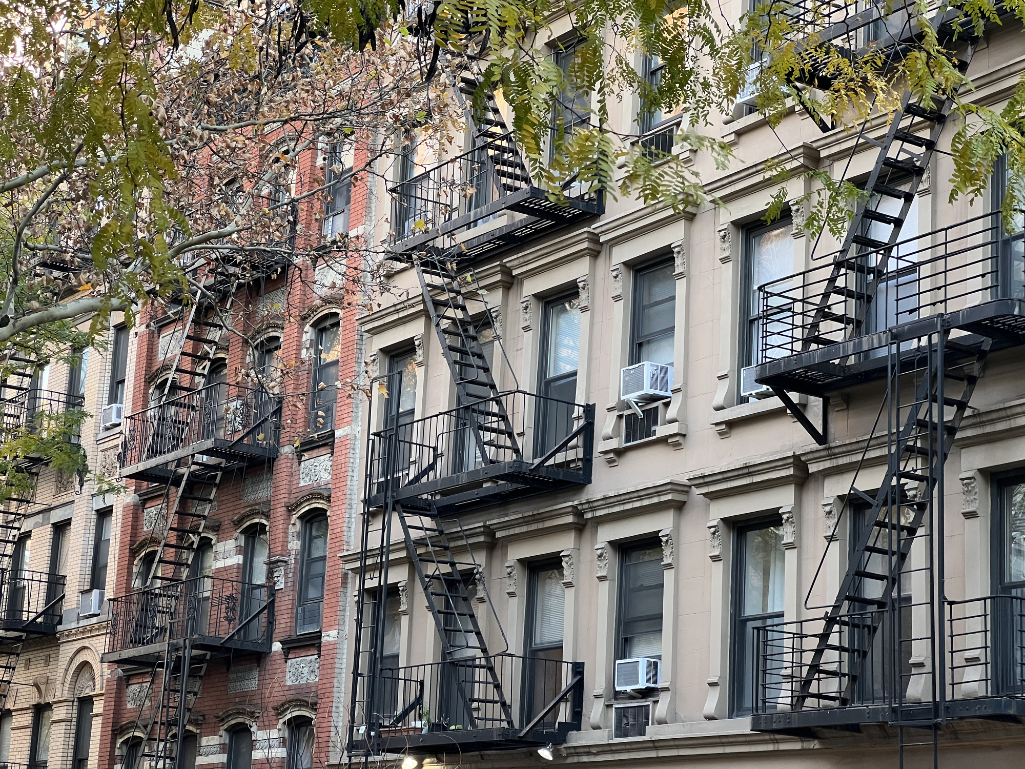 Old colorful buildings with fire ladder and trees on New-york manhattan, Upper East Side, buildings front house