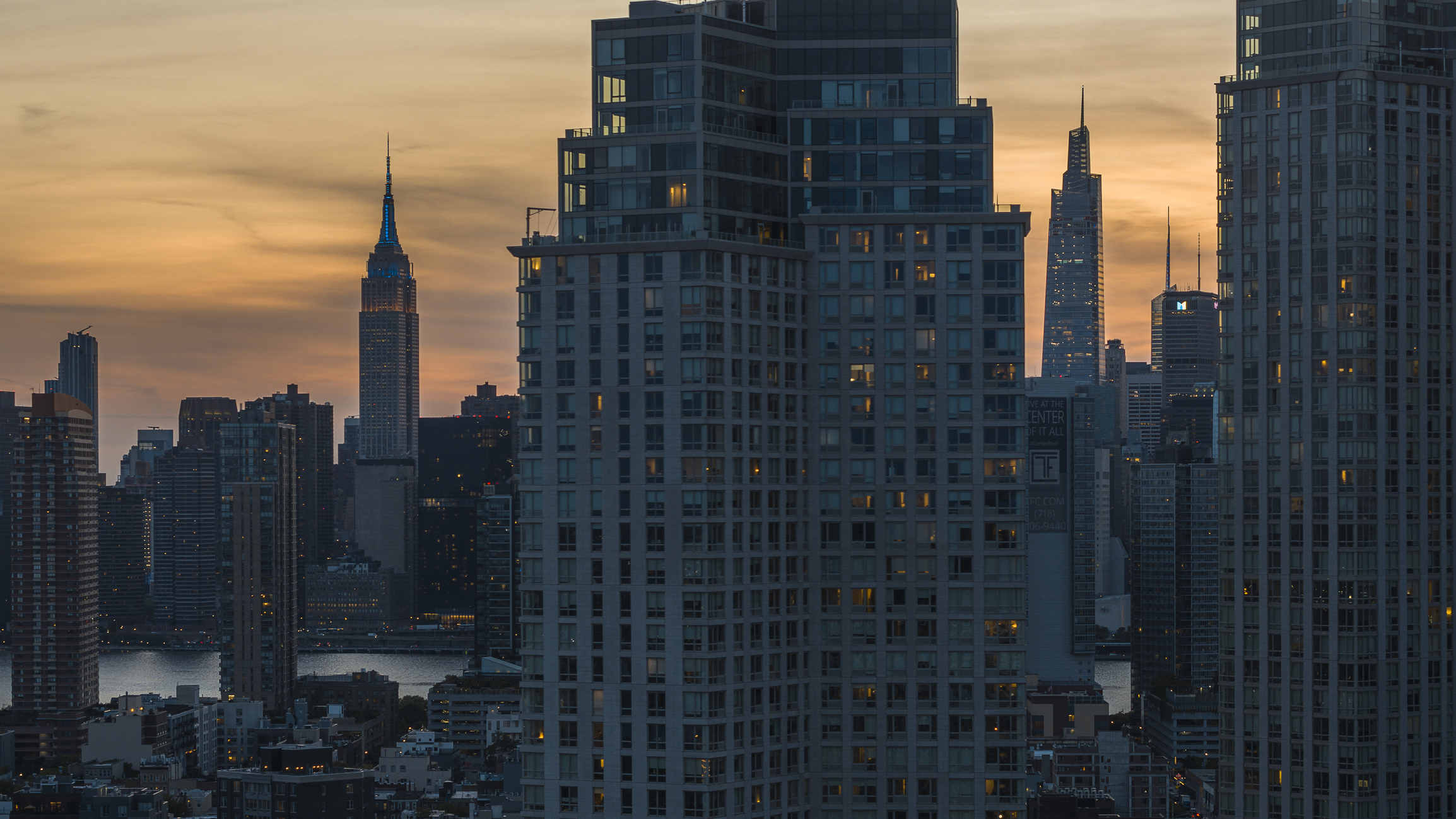 Long Island City waterfront with Empire State Building seen at night.