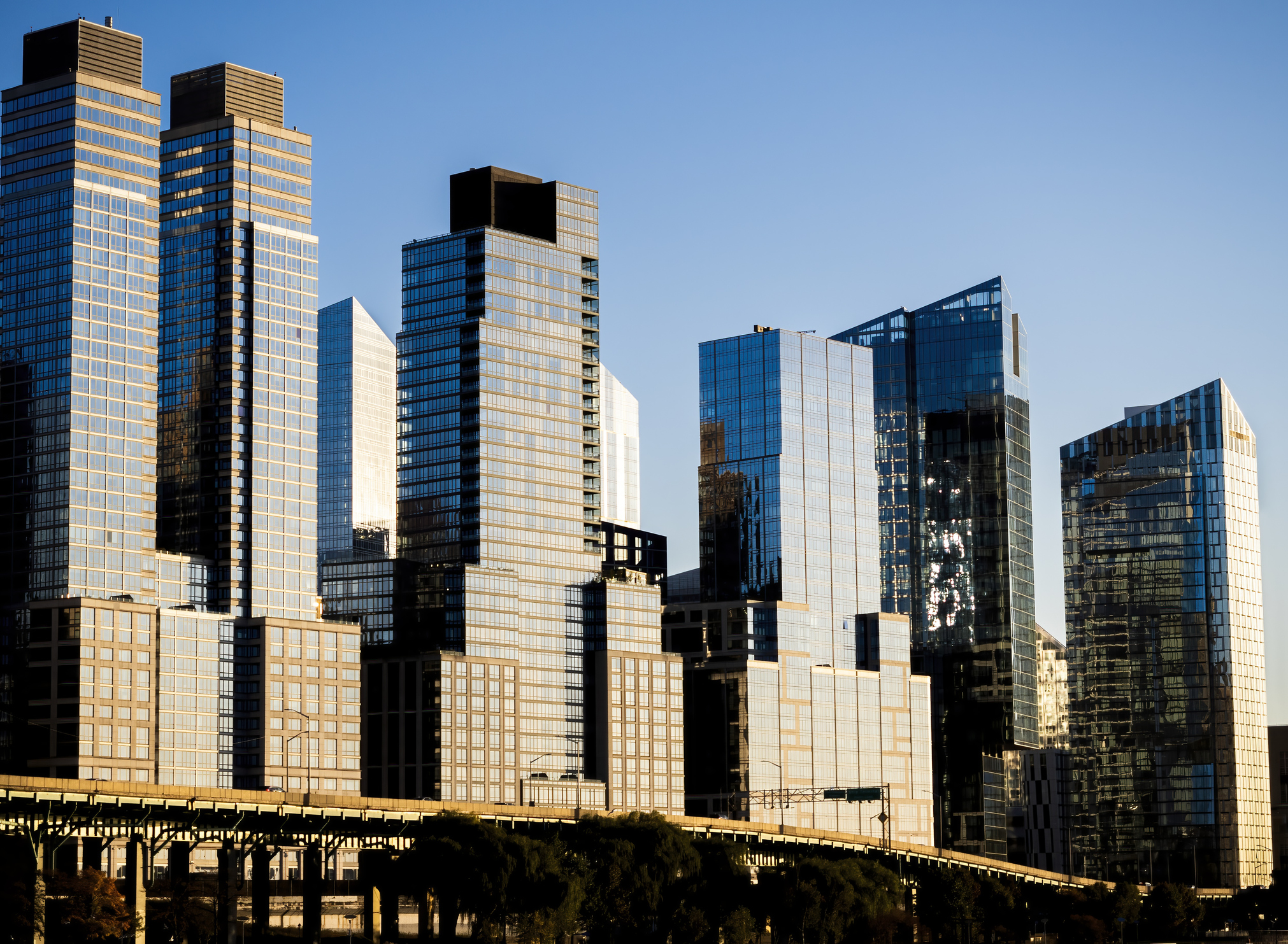 Glimmering steel and glass apartment buildings along the West Side Highway, south of the Henry Hudson Parkway, far west of Manhattan, New York City, on a sunny fall day. Skyline, NYC.