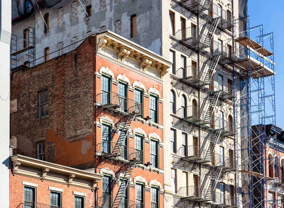 Traditional apartment buildings in New York City, circa 2019, building with scaffolding outside of it.