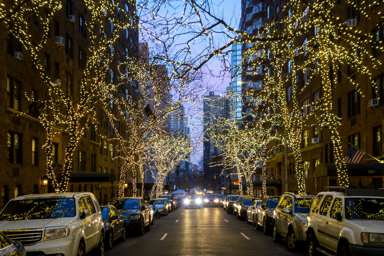 New york city street and brownstone buildings with trees covered in Christmas white lights one point perspective car dusk or early morning stock photo New york city street and brownstone buildings with trees covered in Christmas white lights one point perspective car dusk or early morning stock photo