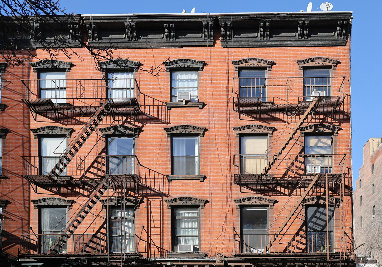 New York City, old apartment building with external fire ladder and ornamental carvings around windows