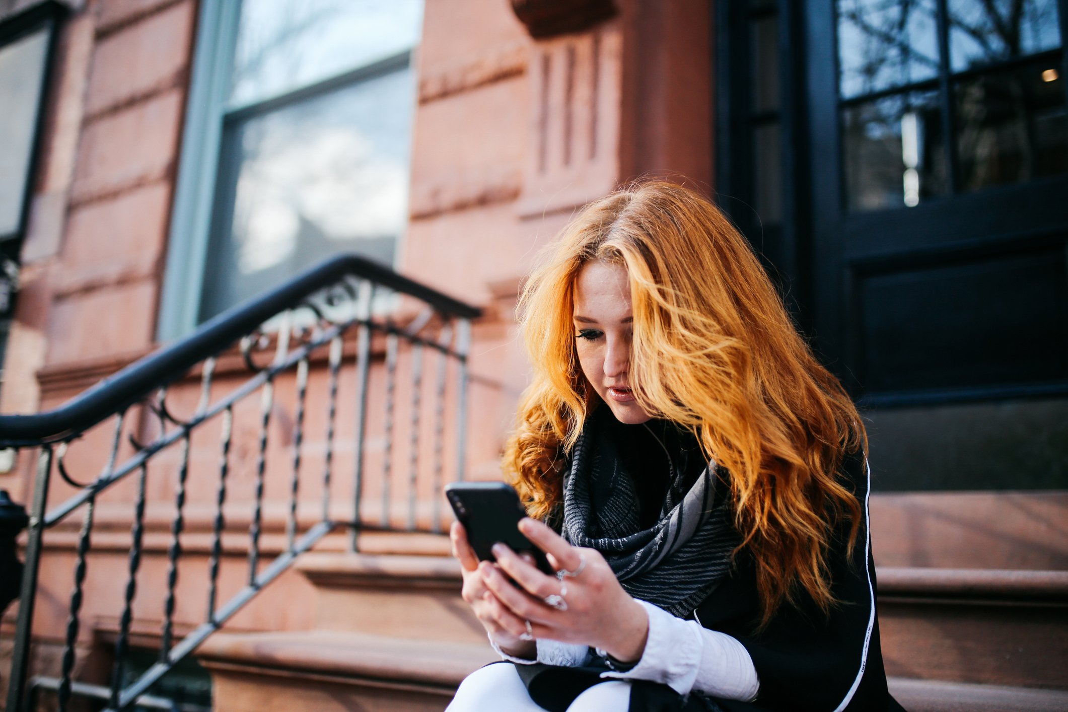 woman looking on her phone for short-term rentals