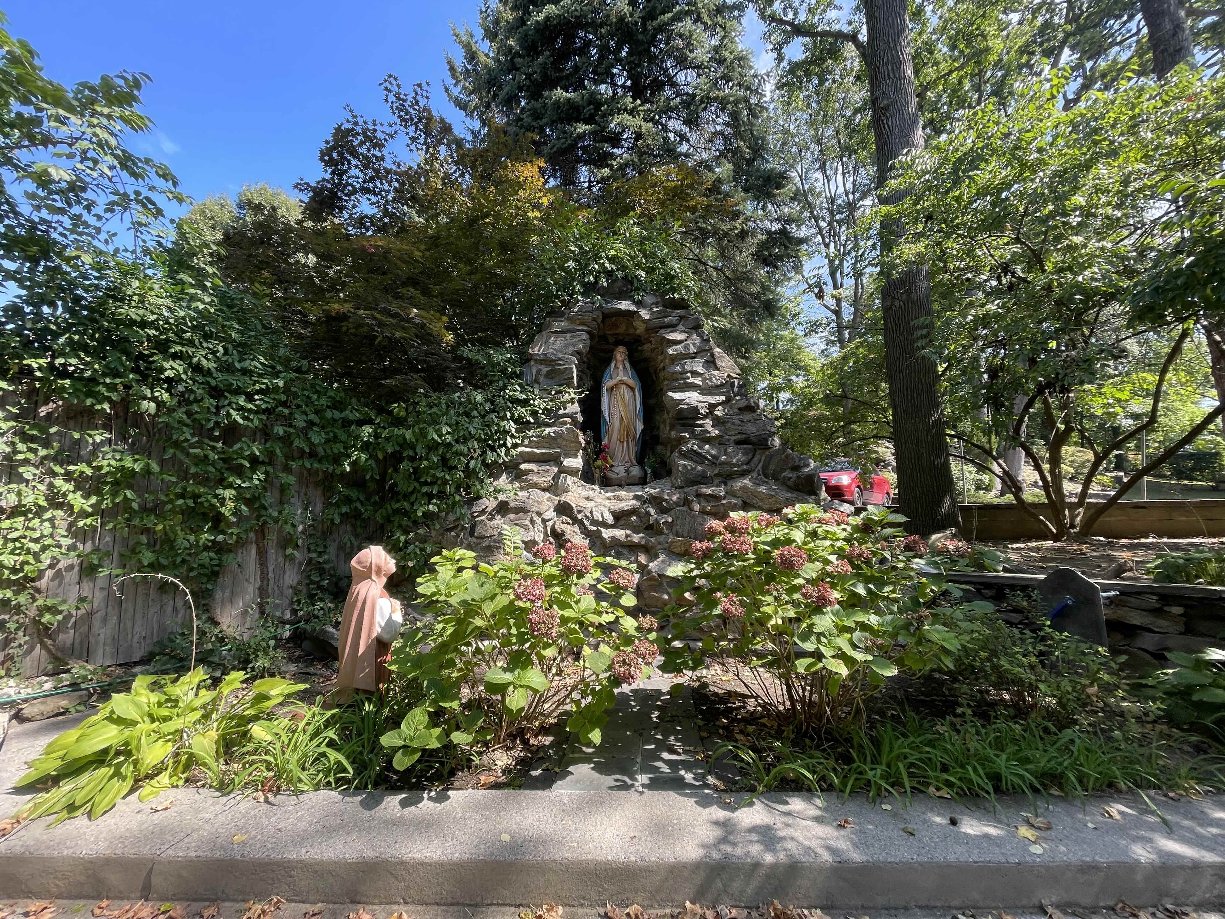 At Centro Maria, tenants can enjoy a small garden near the boarding house. An image of a statue in a garden at Centro Maria