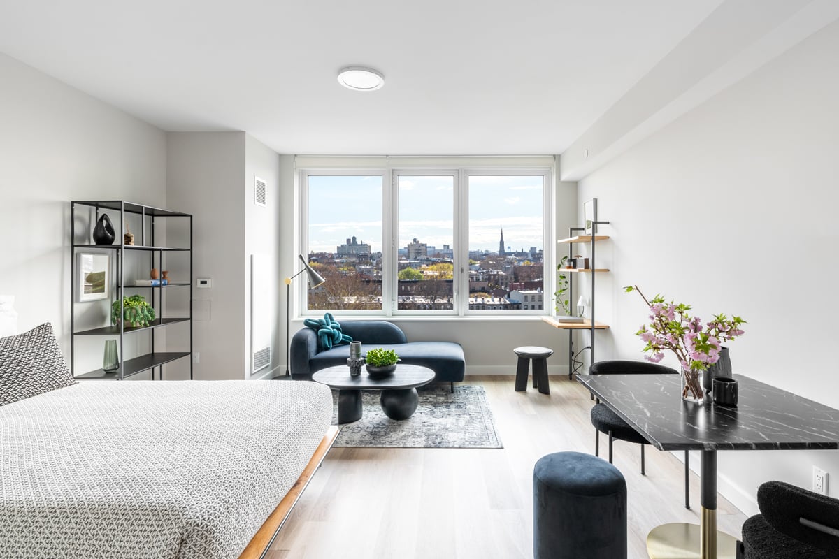 Simple styled bedroom with knit bed spread and view into Brooklyn