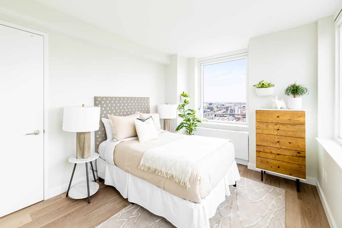 Brightly lit bedroom with two windows from a corner unit