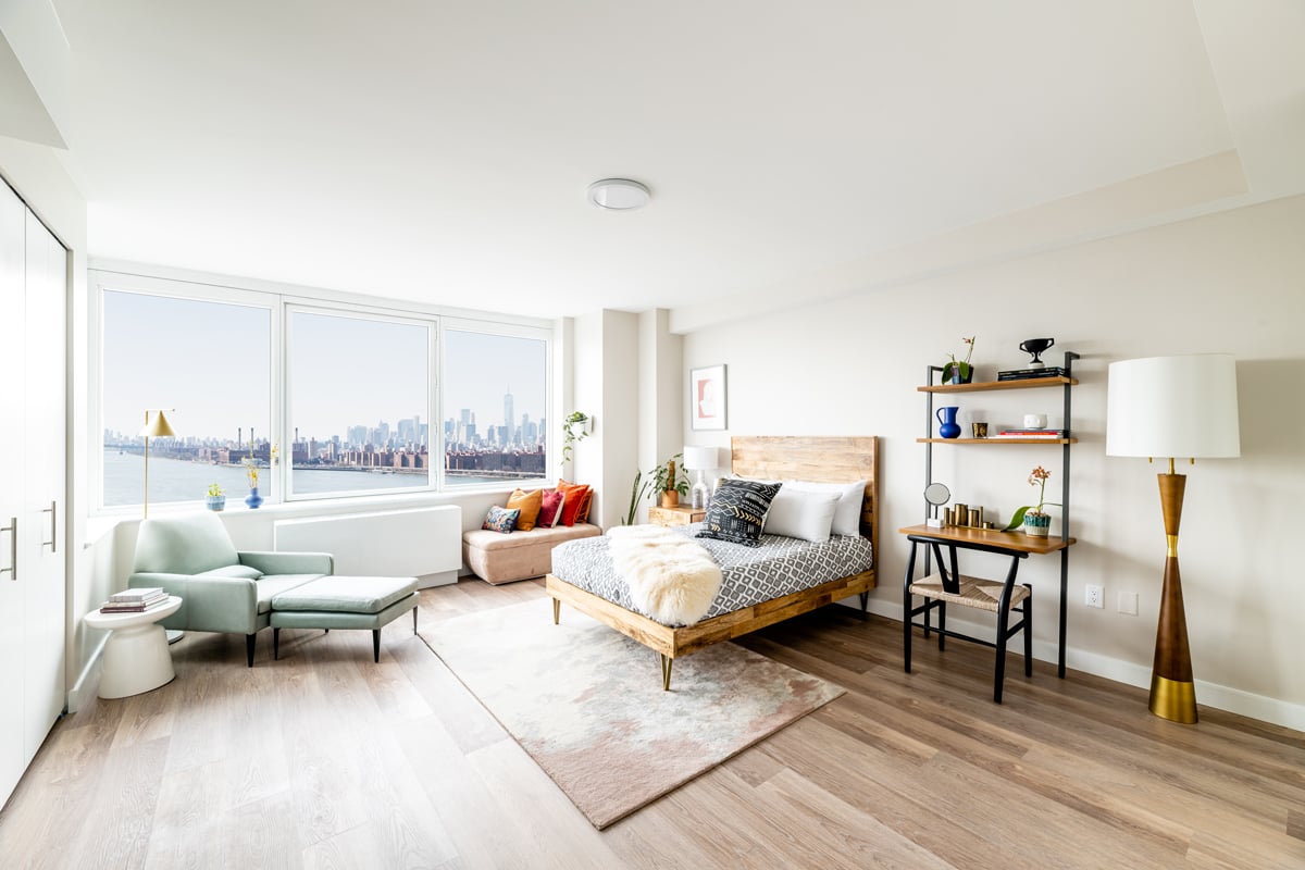 Broader view of bedroom with large closet space and sweeping windows