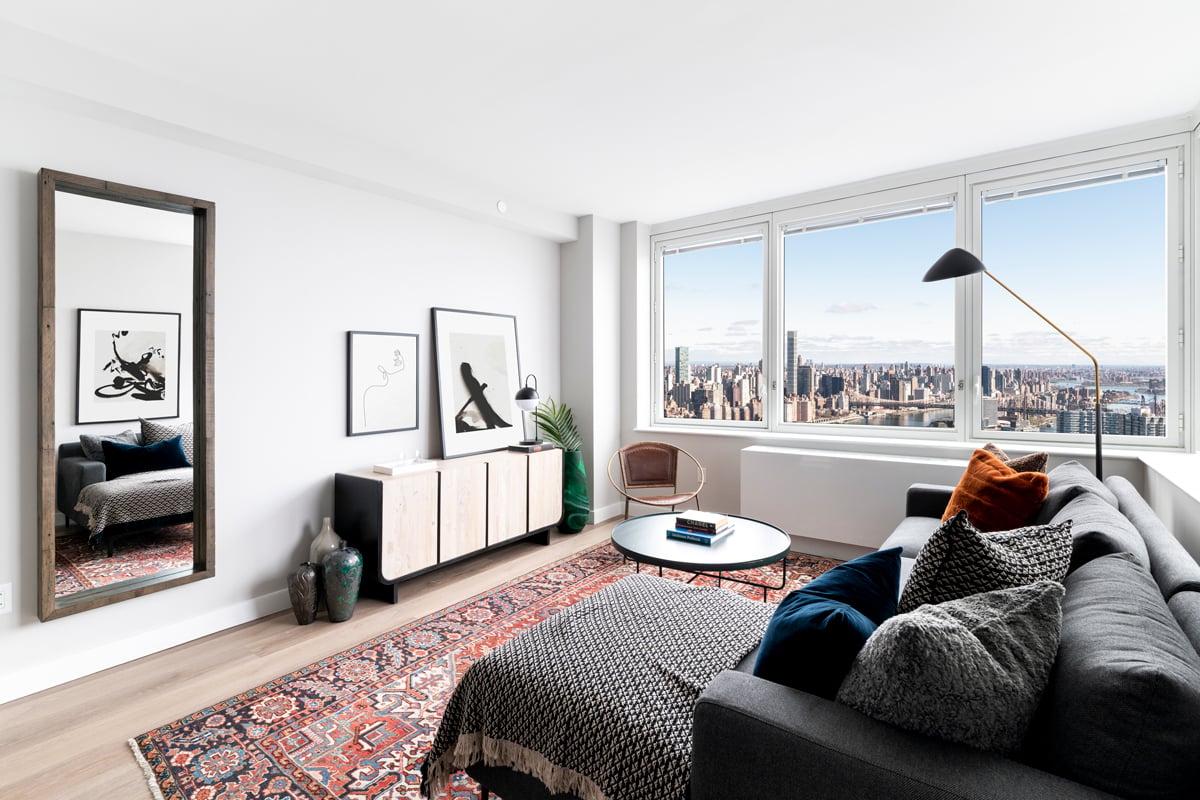 Cozy living room with sectional couch, an area rug, a media console and stunning city views