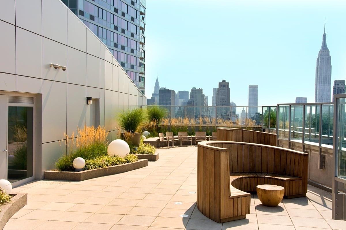 Rooftop patio with wood-panel patio furniture and a view of midtown