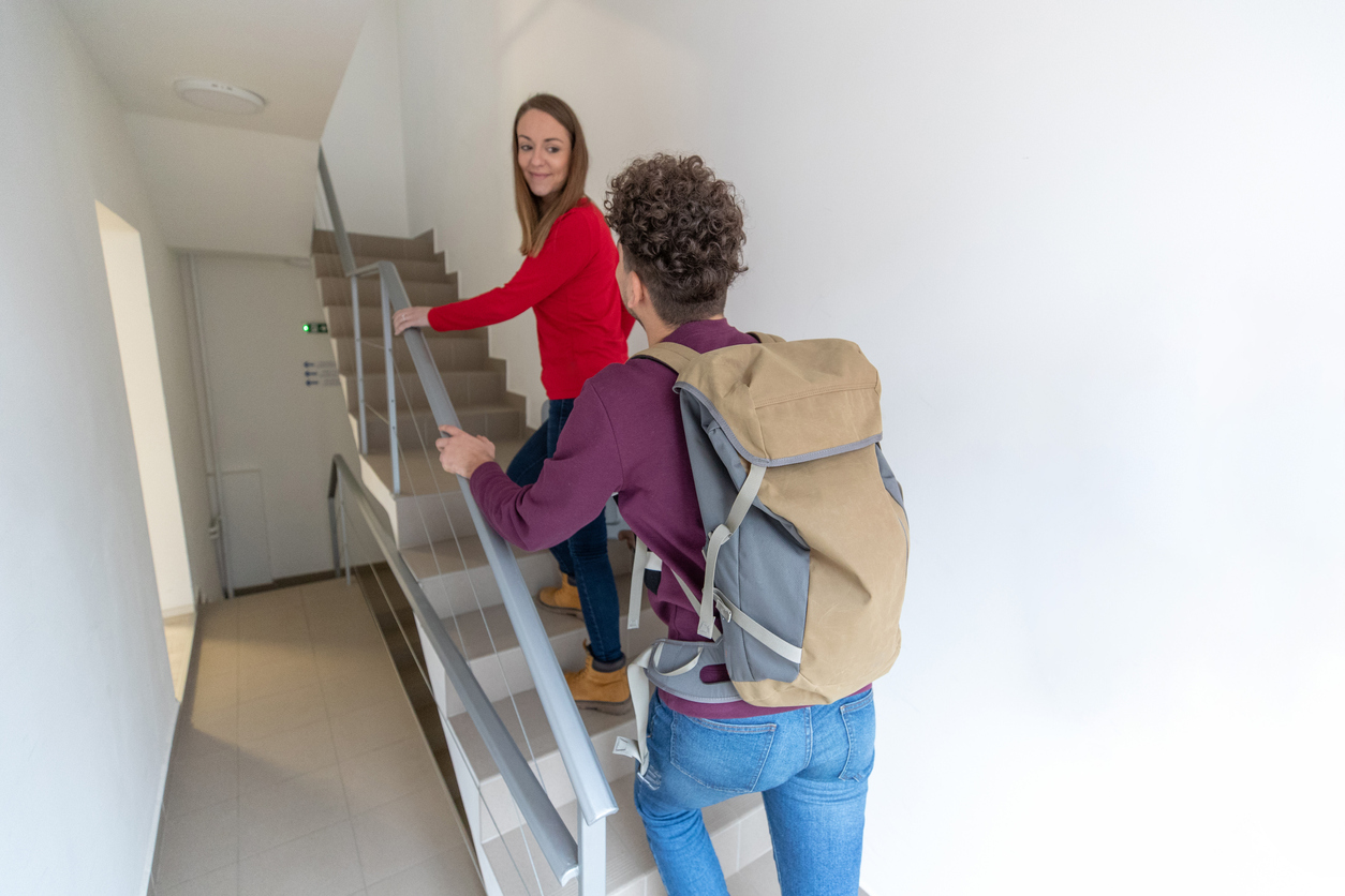 iStock-1131397512.jpg tourists climbing the stairs to their short-term rental in nyc