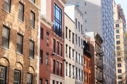 A row of colorful brick residential buildings along a street in Chelsea of New York City