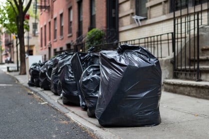 Black Garbage Bags along a Residential Street in Greenwich Village of New York City stock photo Black Garbage Bags sit on a Residential Street in Greenwich Village of New York City.