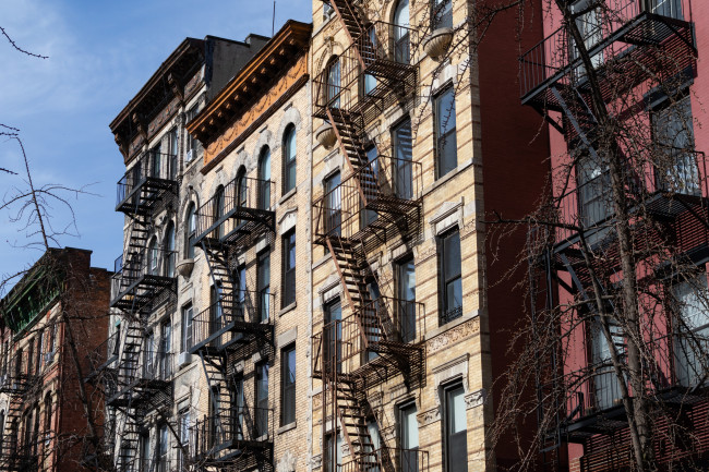 w of Old Brick Apartment Buildings with Fire Escapes in the East Village of New York City - stock photo