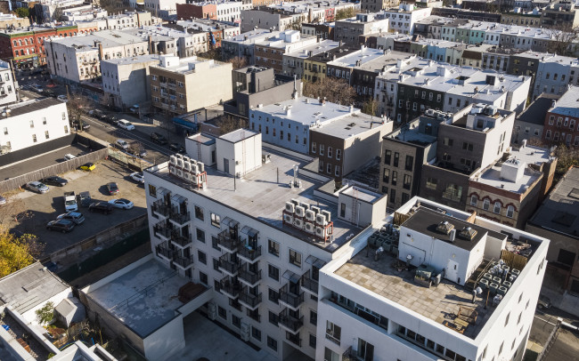 Air conditioners mounted on a rooftop. Residential district of Bushwick, Brooklyn, New York. - stock photo