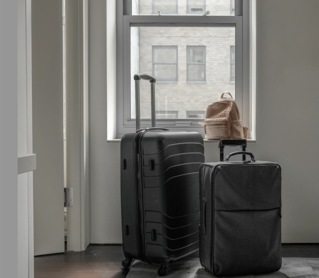 Screenshot 2023-06-05 at 12.10.33 PM.png Suitcases in front of a window looking out on NYC buildings