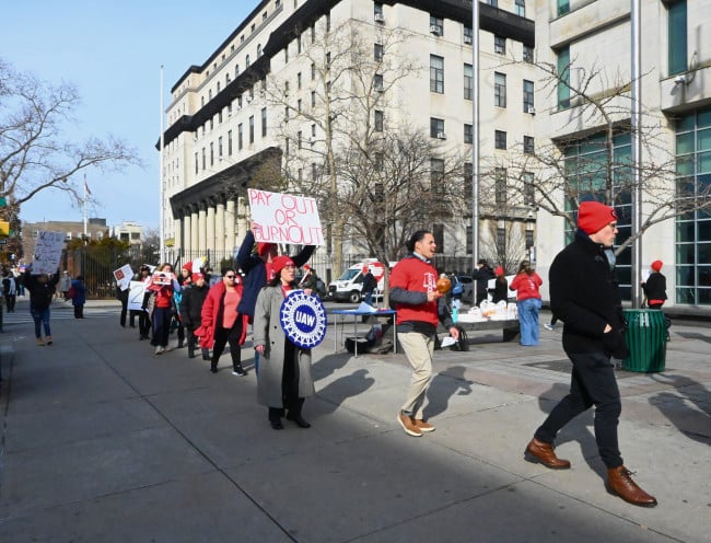 Union members march in a circle on Monday afternoon in front of Queens Civil Court. Union members march in a circle on Monday afternoon in front of Queens Civil Court.