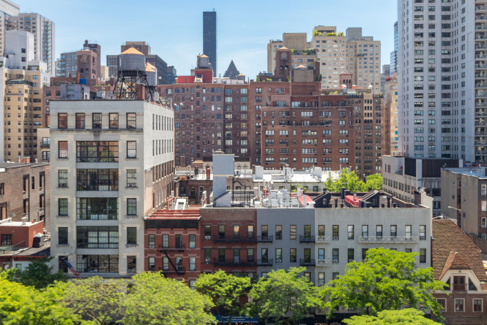 NYC overhead view of historic buildings along 59th Street with the Midtown Manhattan skyline in the background