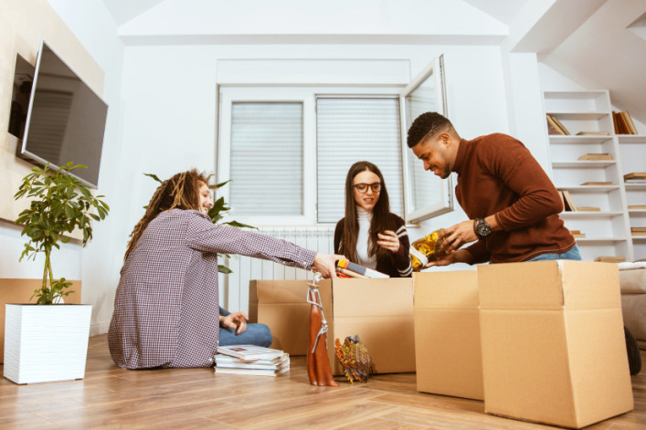 Image of NYC roommates smiling and packing boxes together