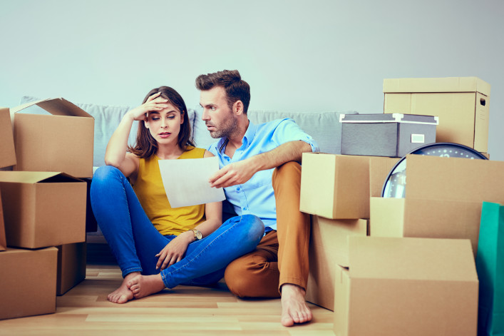 couple moving into apartment surrounded by moving boxes