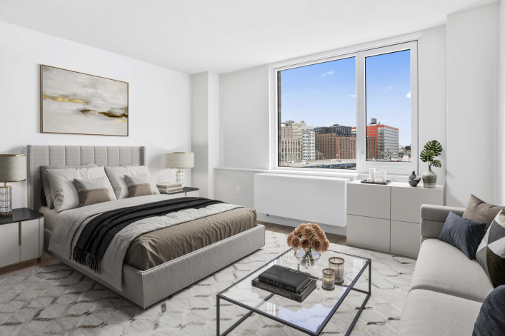Bedroom at Bronx Point, brown bedding, glass coffee table, views of the Bronx and highway