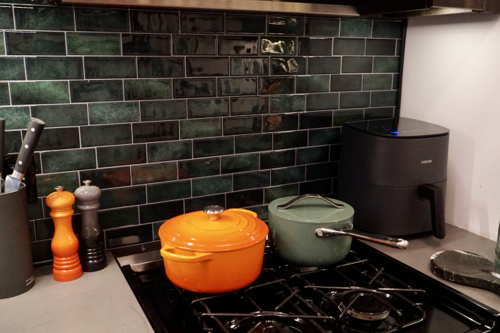 A kitchen backsplash decorated with green tiles.