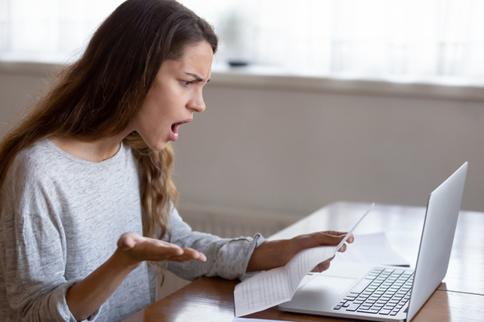 Shocked young woman read bad news in letter at home stock photo