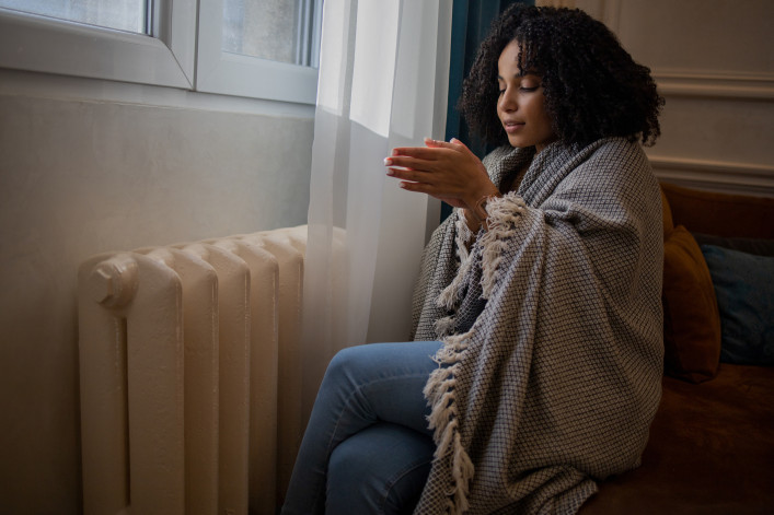 Woman feel cold in home with no heating stock photo