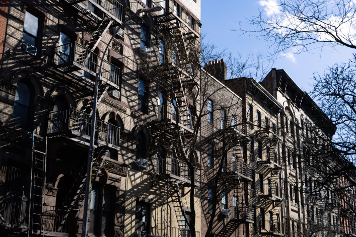 ow of Old Brick Apartment Buildings with Fire Escapes along a Residential Street in Greenwich Village of New York City