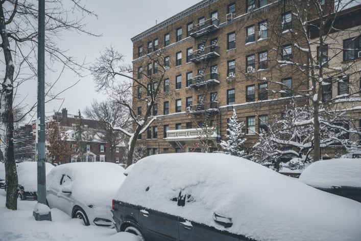 snow covered cars parked along streets in Brooklyn, NY.