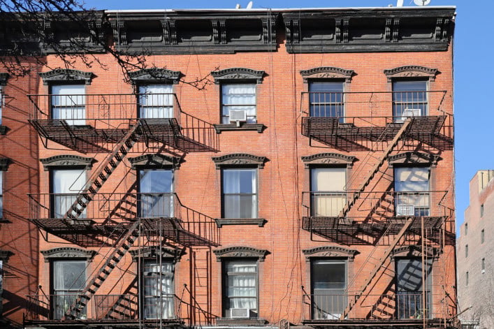 New York City, old apartment building with external fire ladder and ornamental carvings around windows
