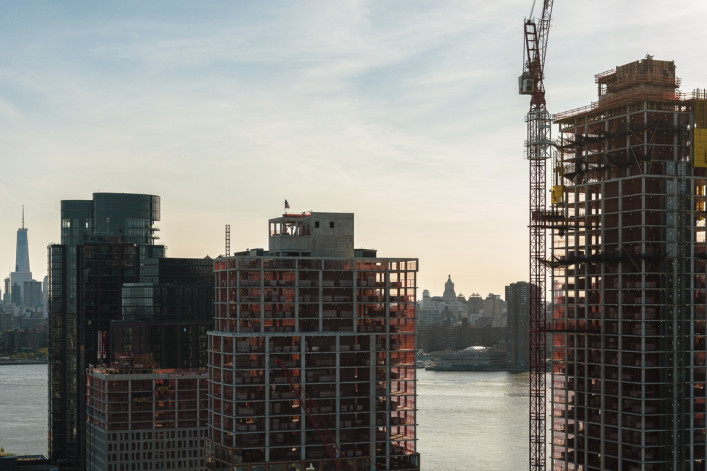 Modern buildings under construction on the waterfront in Greenpoint, Brooklyn with the view of Manhattan with Freedom Tower over the East River.