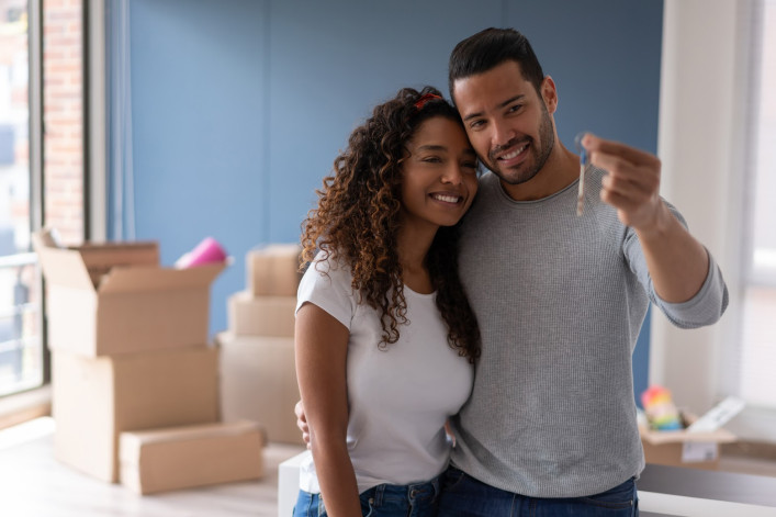 A couple looks at the key to their new apartment