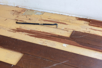 Wood floor partially removed with a tool for levering planks