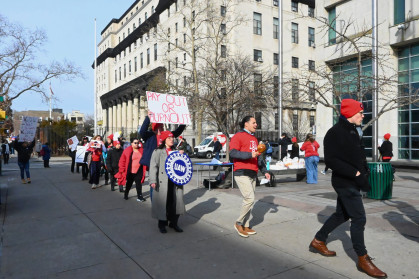 Union members march in a circle on Monday afternoon in front of Queens Civil Court.