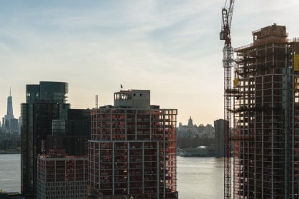 Modern buildings under construction on the waterfront in Greenpoint, Brooklyn with the view of Manhattan with Freedom Tower over the East River.
