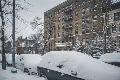 snow covered cars parked along streets in Brooklyn, NY.