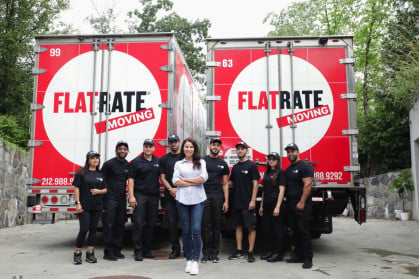 Team members and founder standing in from of two FlatRate Moving trucks