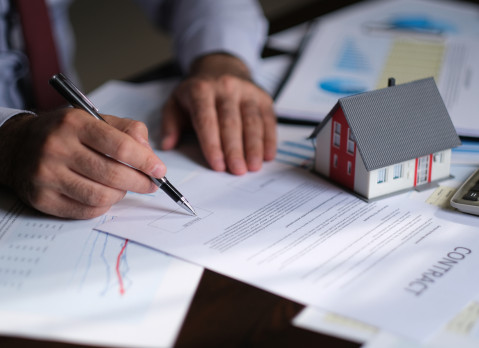 Businessman signing a mortgage contract of a sale for a new house